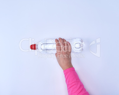 transparent plastic bottle with fresh water in a female hand