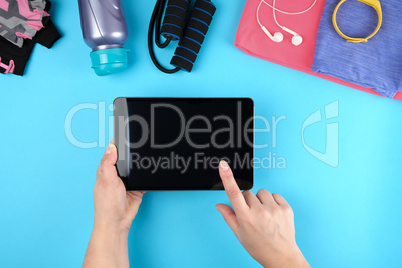 female hands holding an electronic tablet with a blank black scr