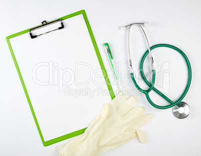 green  medical stethoscope, gloves and green paper holder