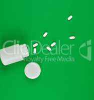 white plastic can and scattered oval pills