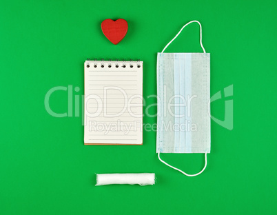 open notebook in line with white sheets, medical mask