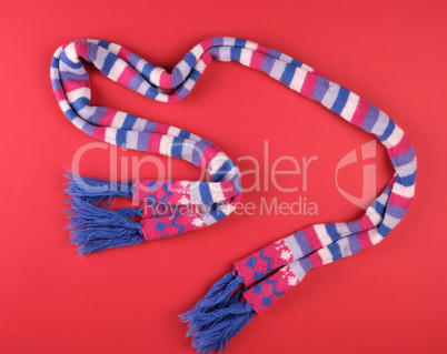 knitted multicolored scarf on a red background