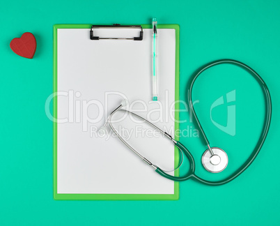 empty white sheets and a medical stethoscope on a green backgrou