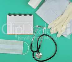 open notebook in line with white sheets, medical mask, stethosco