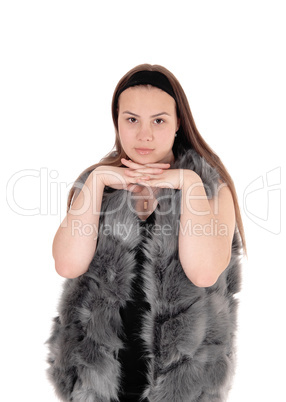 Young girl standing in fur jacket, looking in camera
