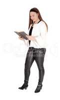 Teenage girl standing in pants holding a book in hands