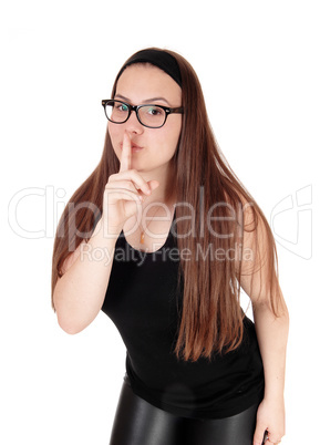 Lovely teenage girl standing with finger over mouths