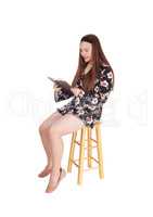 Lovely teenage girl sitting and reading a book
