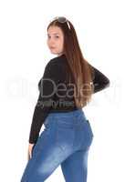 Teenage girl standing in profile in jeans