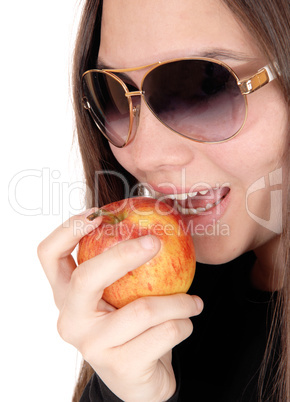 Close up of girl eating a red apple with sunglasses