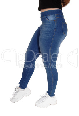 The bottom and legs of a young girl in jeans