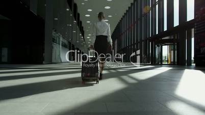 Business woman walking with wheeled bag