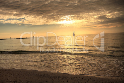 Sailboat against the golden sky of South Marco Island Beach at S