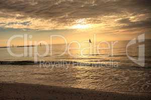 Sailboat against the golden sky of South Marco Island Beach at S