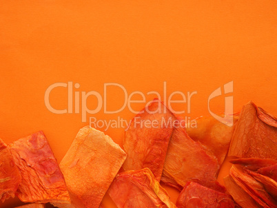 Dried papaya slices on an orange background