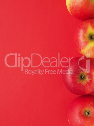 Red organic apples on a red background