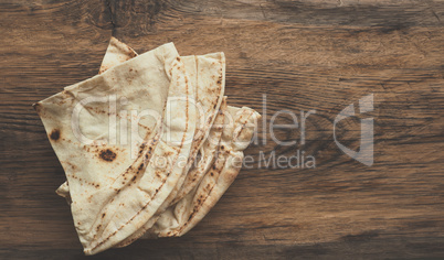Tasty flatbread on a wooden table,
