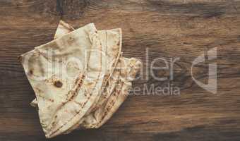 Tasty flatbread on a wooden table,