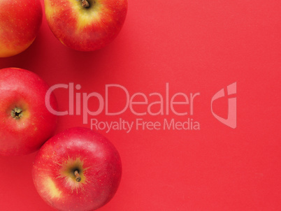 Red organic apples on a red background