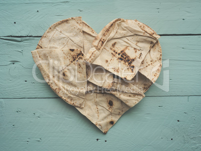 Heart shaped flatbread on a wooden table