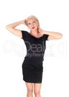 Beautiful woman standing in a short black dress hands on head