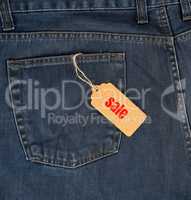 brown paper tag on a rope tied to blue jeans