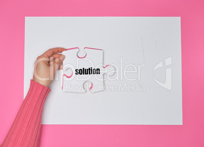 female hand holding white puzzle with the word solution, process