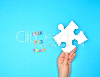 hand hold  large white puzzles and the inscription join our team