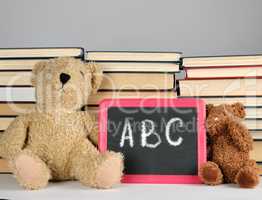 brown teddy bear and empty black board in red frame on the backg