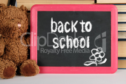 brown teddy bear and black board in red frame