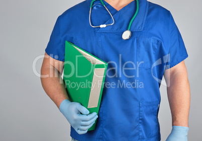 doctor in blue uniform, latex sterile gloves holds in his hand a