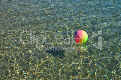 Multicolored beach ball on the sea surface
