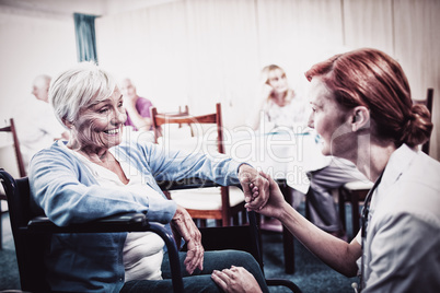 Nurse interacting with a senior woman in wheelchair