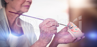 Close-up of female potter painting on bowl