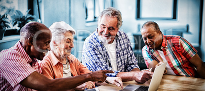 Happy senior men and woman using laptop