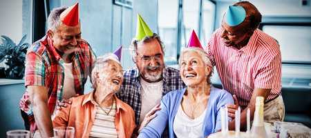 Cheerful friends looking at excited senior woman