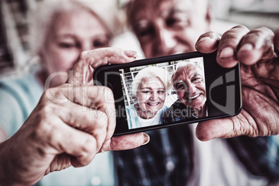 Senior couple taking a photo from mobile phone