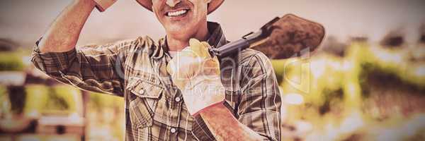 Portrait of farmer carrying shovel