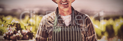 Portrait of a smiling farmer holding box of fruit