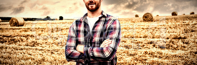 Portrait of farmer standing with arms crossed in the field