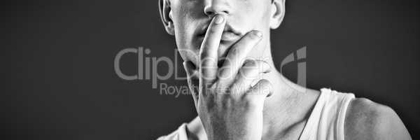 Androgynous man posing with finger on lips