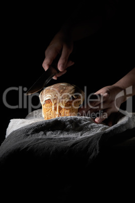women's hands hold a knife over traditional Easter pastries