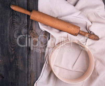 wooden rolling pin on a textile napkin with embroidery and a ro