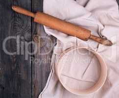 wooden rolling pin on a textile napkin with embroidery and a ro
