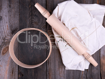 new wooden rolling pin on a textile napkin with embroidery and a