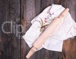 new wooden rolling pin on a textile napkin with embroidery