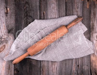 wooden rolling pin on a gray linen napkin