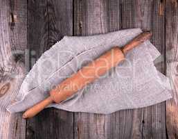 wooden rolling pin on a gray linen napkin