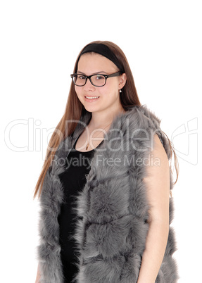 Young smiling girl standing in her fur jacket with glasses