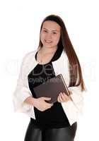 Teenage girl standing white jacket holding a book in hands
